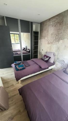 - une chambre avec un grand lit violet dans l'établissement Bergerie entièrement rénovée, à Viggianello