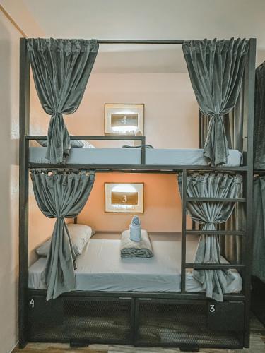a room with two bunk beds with curtains at Outpost Hostel - Coron in Coron