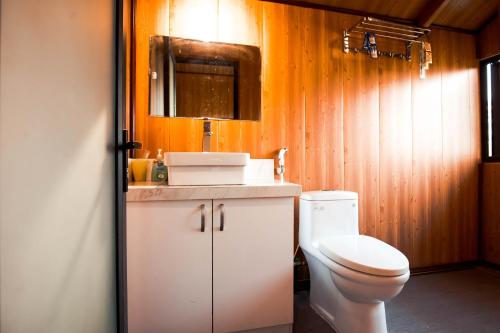 ein Badezimmer mit einem WC, einem Waschbecken und einem Spiegel in der Unterkunft AK Homestay - Motorbike Rental - Cao Bang City in Cao Bằng