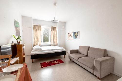 uma sala de estar com uma cama e um sofá em 2ndhomes Bright & Compact Studio with the best loc em Helsinque