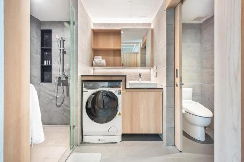 a bathroom with a washing machine and a sink at LiveZen Bangkok Sukhumvit in Khlong Toei