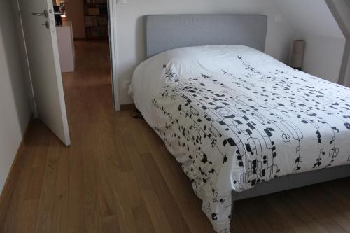 ein Schlafzimmer mit einem Bett mit einer weißen Bettdecke in der Unterkunft La Pérenne in Pénestin