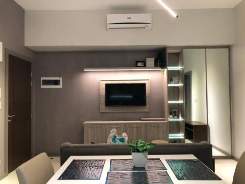 a living room with a table and a television at One Uptown Residence in Manila