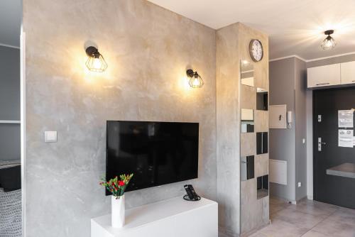 a living room with a flat screen tv on a wall at Apartament Nad Stawem in Gdańsk