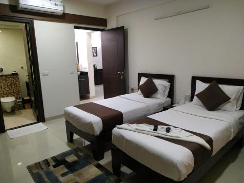 een hotelkamer met 2 bedden en een kamer met bij Luxury 3BhK Service Apartment Manyata tech Park Hebbal in Bangalore