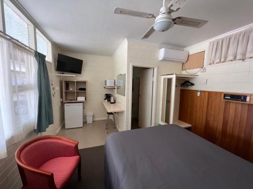 WinkieGlossop Motel的一间卧室，配有一张床、一把椅子和一张书桌