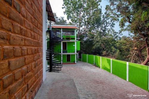 a building with a green wall and a staircase at Paradise Le Tamarin in Auroville