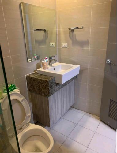 a bathroom with a sink and a toilet at One Uptown Residence in Manila