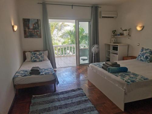 a living room with two beds and a balcony at Artists house in Rivière Noire