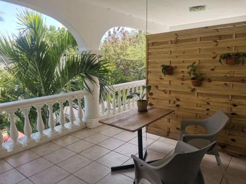 a balcony with a wooden wall and a table and chairs at Artists house in Rivière Noire