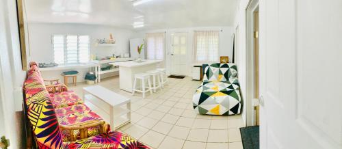 a living room with a couch and a kitchen at Tonga Cottage - Private Double Room Shared Facility in Folaha