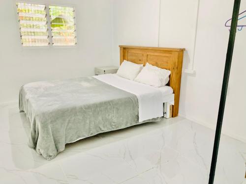 a white bedroom with a bed with white sheets at Tonga Cottage - Private Double Room Shared Facility in Folaha