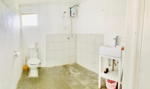 a bathroom with a toilet and a sink at Tonga Cottage - Private Double Room Shared Facility in Folaha