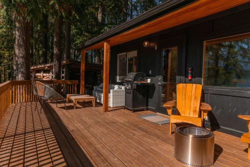 Kootenay Lakeview Retreats - Forest Cabin في ناكوسب: شاشة في شرفة منزل مع سطح