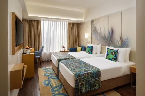 a hotel room with two beds and a desk at WOW Crest, Indore - IHCL SeleQtions in Indore