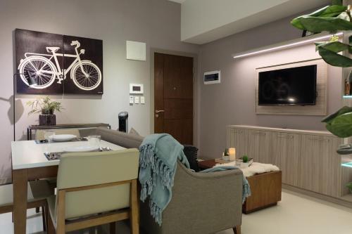 a living room with a table and a bike on the wall at One Uptown Residence in Manila