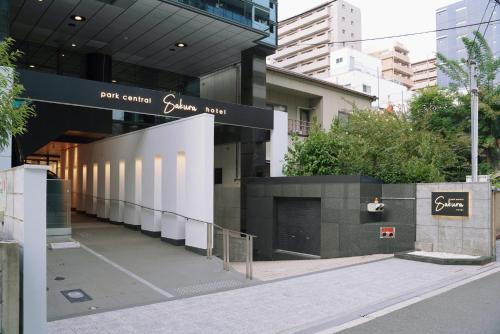 a building with a parking lot in front of it at Park Central Sakura Hotel in Osaka