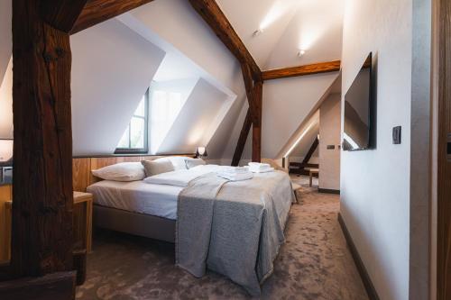 a bedroom with a large bed in a attic at Hotel ALBRECHT in Bratislava