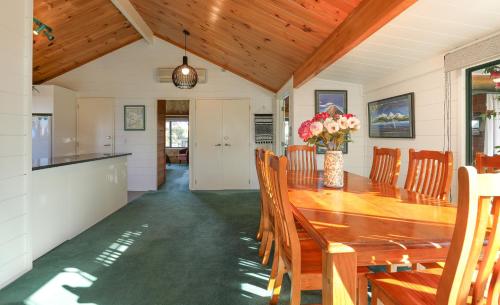 a kitchen and dining room with a wooden table and chairs at Five Mile Yay - Five Mile Bay Holiday Home in Taupo