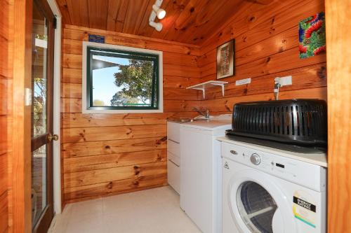a laundry room with a washer and dryer in a cabin at Five Mile Yay - Five Mile Bay Holiday Home in Taupo