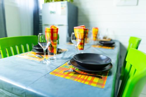 une table bleue avec une plaque et des verres dessus dans l'établissement La villa du soleil 971, à Anse-Bertrand
