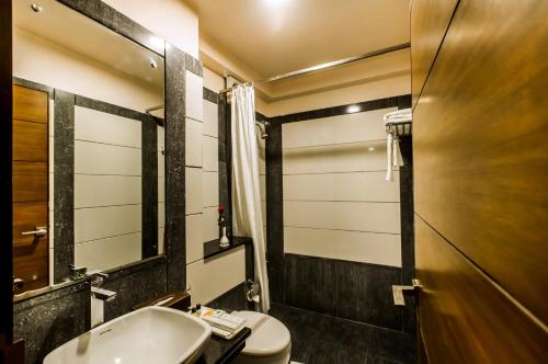 uma casa de banho com um lavatório, um WC e um espelho. em Golden Manor By Brand My Hotel em Jaipur