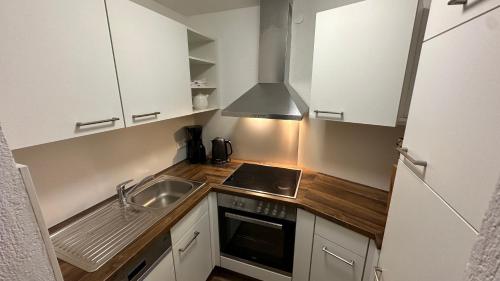 a small kitchen with white cabinets and a sink at Gästehaus Garber in Stumm