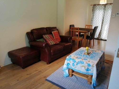 a living room with a couch and a table at Beacons view in Hirwaun