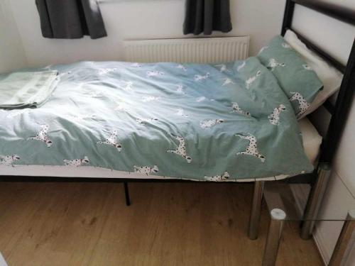 a bed with a blanket on top of it at Beacons view in Hirwaun