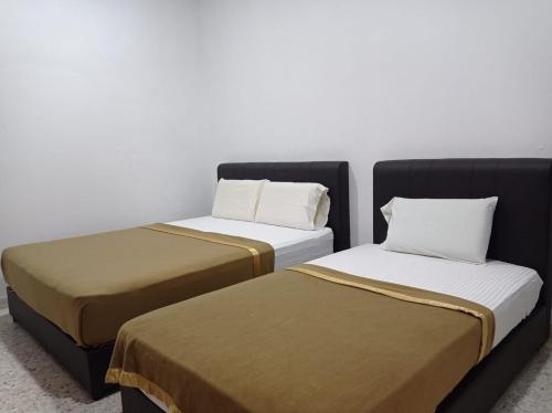 two beds sitting next to each other in a room at E1397 Guest House in Kuantan