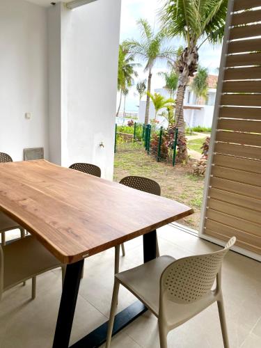 a dining room with a wooden table and chairs at Villa TE URA Beach in Paea