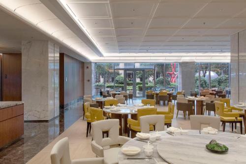 uma sala de jantar com mesas e cadeiras amarelas em Sheraton Grand Shanghai Pudong Hotel & Residences em Xangai
