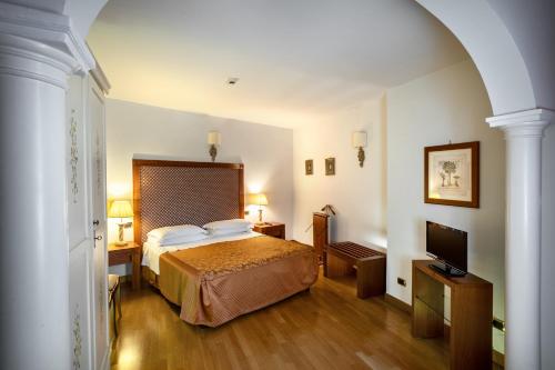 Habitación de hotel con cama y TV en Relais Le Felci Executive Suite Spa, en Fiuggi