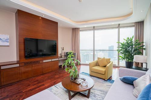 a living room with a television and a couch at The Grand View Hotel Changzhou in Changzhou