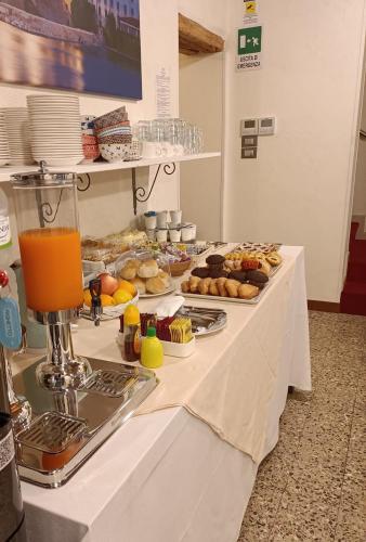 a table with a buffet of pastries and orange juice at LOCANDA RIGHETTO in Quinto di Treviso