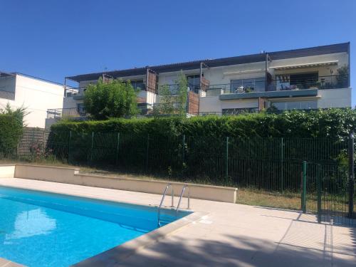 une piscine devant un immeuble dans l'établissement T2 avec piscine et terrasse dans résidence arborée, à La Rochelle