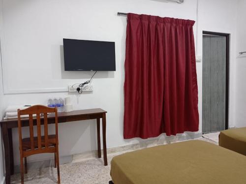 a room with a desk and a red curtain at E1397 Guest House in Kuantan