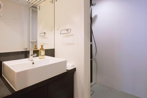 a bathroom with a white sink and a mirror at Park Central Sakura Hotel in Osaka