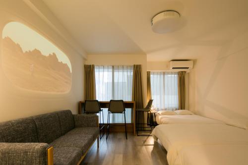 a hotel room with two beds and a couch at trive meieki nishi 105 最大6名宿泊可 名古屋駅まで1駅 太閤通駅徒歩4分 in Nagoya
