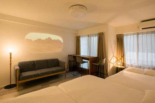 a hotel room with a bed and a couch and a desk at trive meieki nishi 105 最大6名宿泊可 名古屋駅まで1駅 太閤通駅徒歩4分 in Nagoya