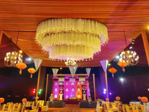 a large chandelier hanging from the ceiling of a room at The Stella Hotel & Resort in Ludhiana