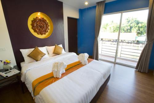 a hotel room with two beds and a large window at Korbua House in Bangkok