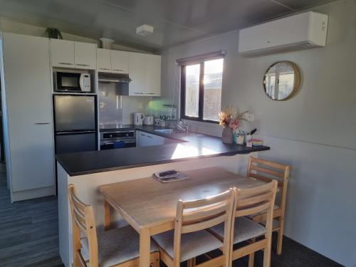 cocina con mesa y sillas en PWL Healing Retreat Accommodation en Rotorua