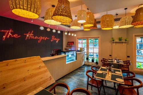 a restaurant with tables and chairs and pendant lights at De Fleur Hotel in Puducherry