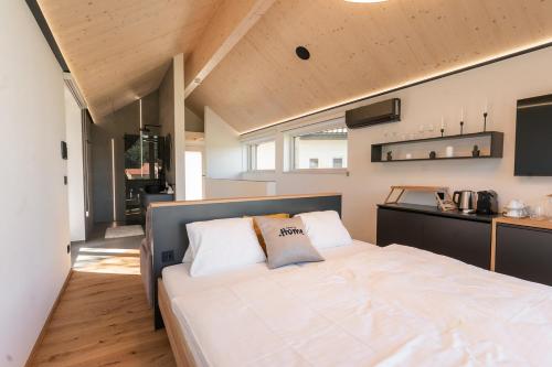a bedroom with a large white bed and a kitchen at Chalet5 in Sankt Martin im Innkreis