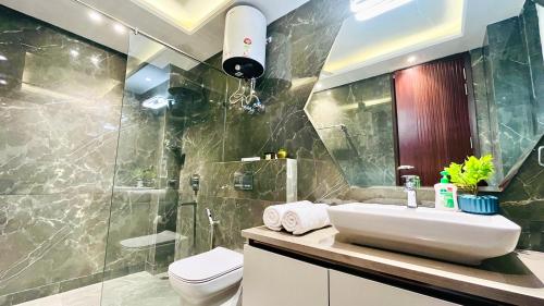 ein Bad mit einem Waschbecken, einem WC und einer Dusche in der Unterkunft Olive Service Apartments - DLF Cyber City in Gurgaon