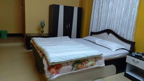 a bedroom with a large bed with white sheets and pillows at Oak valley retreat in Pelling