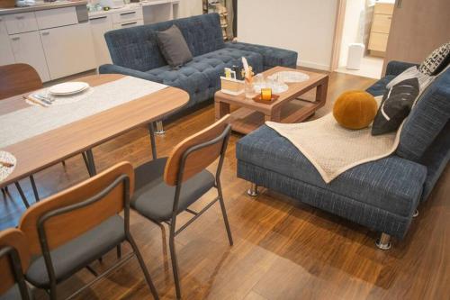 a living room with a blue couch and a table at 银座合之屋 筑地市场地铁三分钟 银座徒步十分钟 in Tokyo