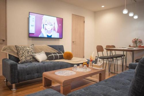 a living room with a couch and a tv on the wall at 银座合之屋 筑地市场地铁三分钟 银座徒步十分钟 in Tokyo