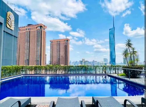 a swimming pool on the roof of a building with tall buildings at Cosy Unit 5 min walk KL Pavilion KLCC by Elefen Homestay in Kuala Lumpur